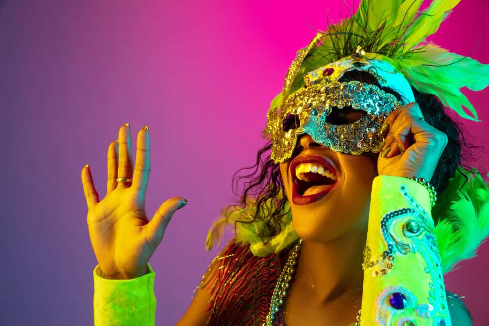 Viaggio a Tenerife, spendi poco e trovi l’Estate anche d’Inverno 3 bella giovane donna in carnevale elegante costume in maschera con piume sulla parete sfumata in luce al neon
