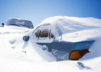 cars covered with snow in the winter blizzard